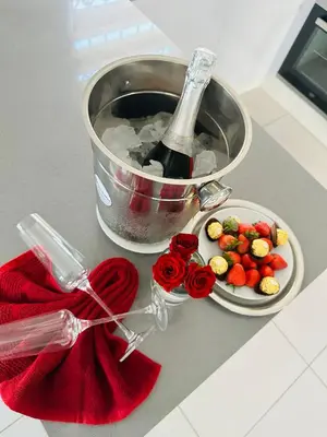 a bottle of wine and a plate of fruit and a bowl of roses at Kings View Exclusive Villas (KVEV) in Petronella