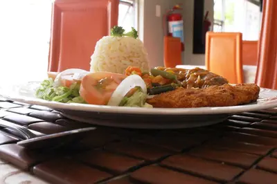 a plate of food with rice and vegetables on a table at Muofhe Graceland Lodge in Thohoyandou