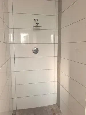 a shower with white tile walls and a faucet at Karee Gardens B&B in Springs
