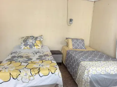 a small room with two beds and a bedskirts at Karee Gardens B&B in Springs