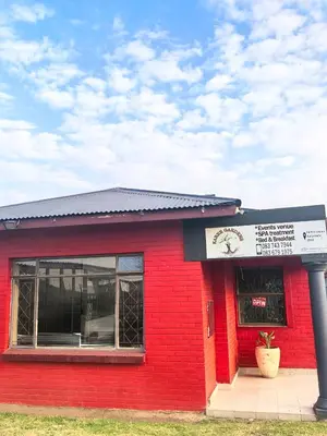 a red building with a sign in front of it at Karee Gardens B&B in Springs