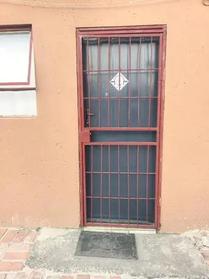 a door with a metal gate on the side of a building at Karee Gardens B&B in Springs