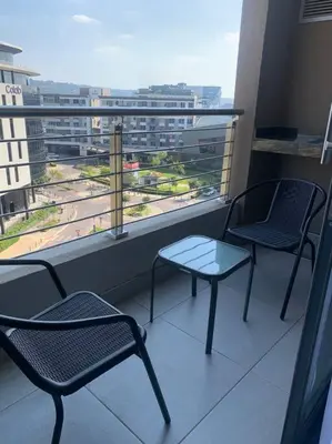two chairs and a table on a balcony with a view at Entire Studio Apartment at The Capital Triology in Pretoria
