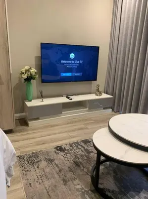 a living room with a flat screen tv on a tv stand at Entire Studio Apartment at The Capital Triology in Pretoria