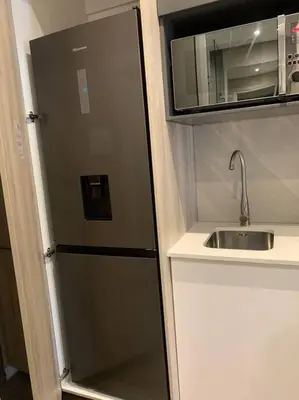a kitchen with a refrigerator next to a sink at Entire Studio Apartment at The Capital Triology in Pretoria