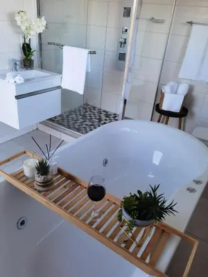 a bath tub in a bathroom with a sink and a shower at Kings view exclusive villas (KVEV) in Pretoria-Noord