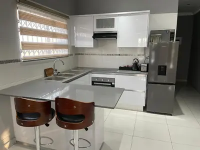a kitchen with a counter and a sink and a refrigerator at Kings view exclusive villas (KVEV) in Pretoria-Noord