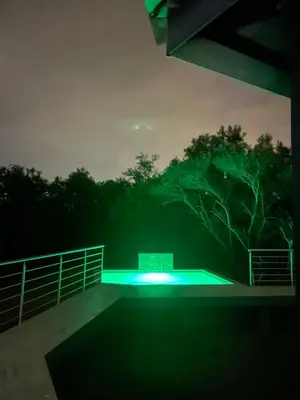 a night view of a swimming pool with green lights at Kings view exclusive villas (KVEV) in Pretoria-Noord