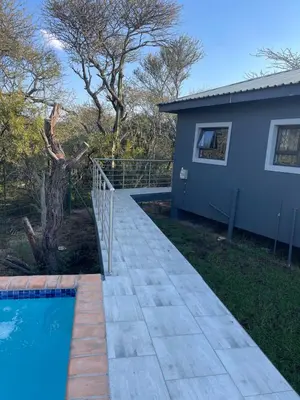 a walkway leading to a house and a swimming pool at Kings view exclusive villas (KVEV) in Pretoria-Noord