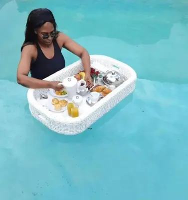 a woman in the water with a tray of food at Kings view exclusive villas (KVEV) in Pretoria-Noord