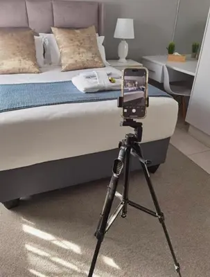 a camera on a tripod next to a bed at Kings view exclusive villas (KVEV) in Pretoria-Noord
