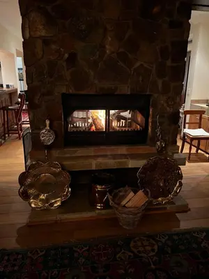 a fireplace in a living room with a stone wall at iDube Lodge Walkersons in Dullstroom