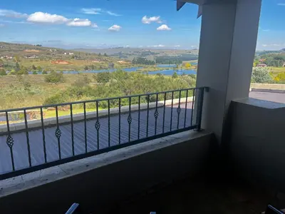 a balcony with a view of a river at iDube Lodge Walkersons in Dullstroom