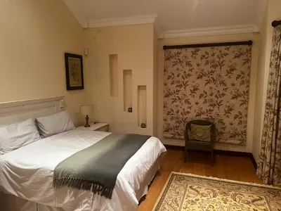 a bedroom with a bed and a large window at iDube Lodge Walkersons in Dullstroom