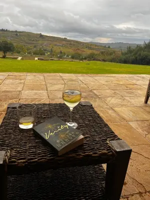 a glass of wine and a book on a table at iDube Lodge Walkersons in Dullstroom
