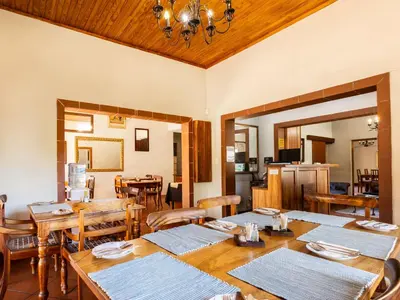 a dining room with wooden tables and chairs at Schoongezich Guesthouse in Pretoria