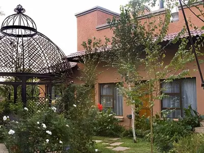 a house with a gazebo and a garden at Schoongezich Guesthouse in Pretoria