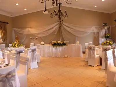 a banquet room with white tables and white chairs at Schoongezich Guesthouse in Pretoria