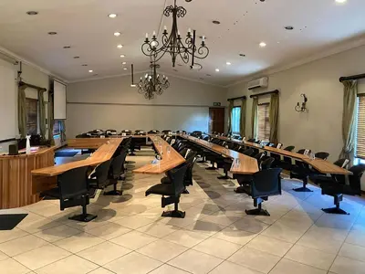 a large conference room with wooden tables and chairs at Schoongezich Guesthouse in Pretoria