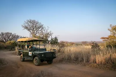 a green jeep driving down a dirt road at Zebula Golf Estate and Spa - Zebula Golfers Lodge in Mabula