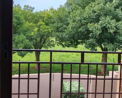 a balcony with a view of a park with trees at Lady D Exclusive Abode in Polokwane