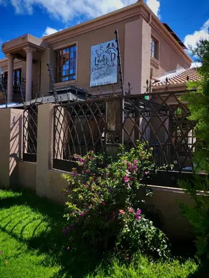 a house with a fence and flowers in front of it at Lady D Exclusive Abode in Polokwane