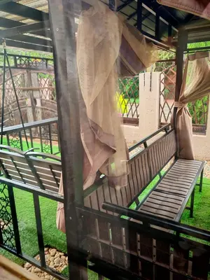 a bench in a park with a window at Lady D Exclusive Abode in Polokwane