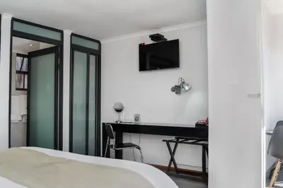 a bedroom with a desk and a tv on the wall at Yalla Yalla Boutique Hotel in Witbank