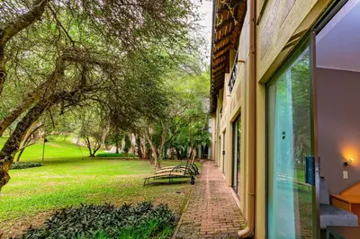 a window of a building with a bench in a park at Sanbonani Hotel in Hazyview