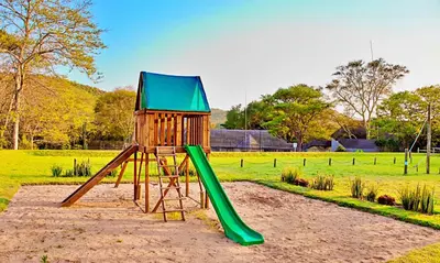 a playground with a green slide in a park at Sanbonani Hotel in Hazyview