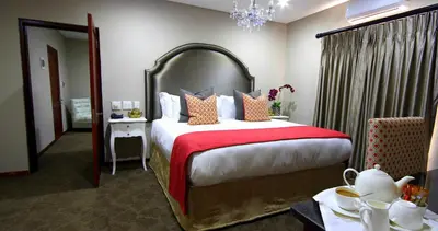 a bedroom with a large bed with a red blanket at La Villa Vita in Nelspruit