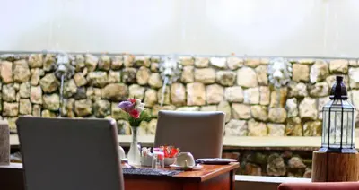 a table with two chairs and a table with flowers on it at La Villa Vita in Nelspruit