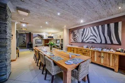 a large dining room with a long table and a large screen at Zebrina Guest House in Nelspruit