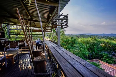a person sitting on the deck of a house at Zebrina Guest House in Nelspruit
