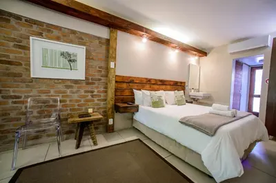 a bedroom with a bed and a brick wall at Zebrina Guest House in Nelspruit