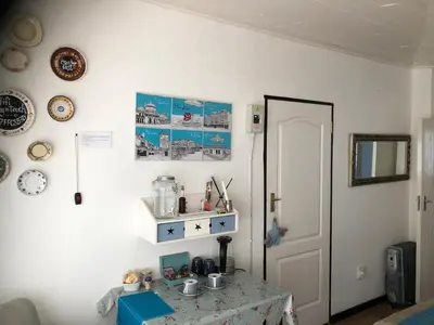 a white room with a table with a blue table cloth at Peace Corner Cottages in Dullstroom