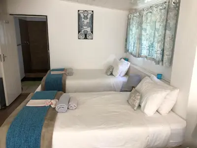 a room with two beds and a couch at Peace Corner Cottages in Dullstroom