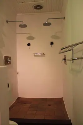 a bathroom with a white wall with lights on it at Peace Corner Cottages in Dullstroom