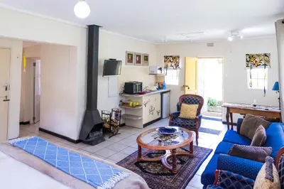 a living room with a blue couch and a fireplace at Peace Corner Cottages in Dullstroom
