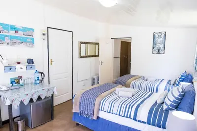 a bedroom with two beds and a desk at Peace Corner Cottages in Dullstroom