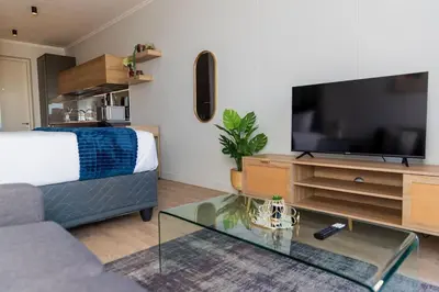 a living room with a bed and a tv at Luxe Cityscape @ Waterfall Ellipse in Midrand