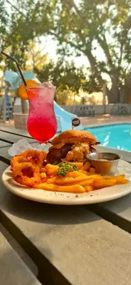 a plate of food on a table with a drink at Mabalel in Crocodile Valley Estates