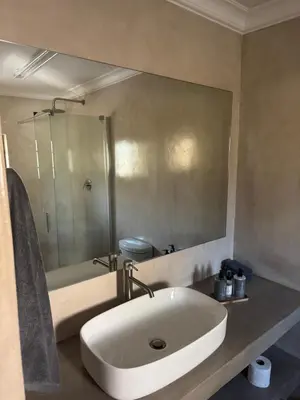 a bathroom with a white sink and a shower at Mabalel in Crocodile Valley Estates