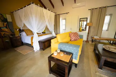 a living room with a couch and a bed at Oriole Bush Cottage in Hoedspruit