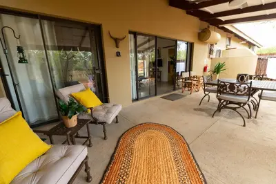 a living room with a couch and chairs and a table at Oriole Bush Cottage in Hoedspruit