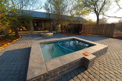 a swimming pool in the middle of a yard at Oriole Bush Cottage in Hoedspruit