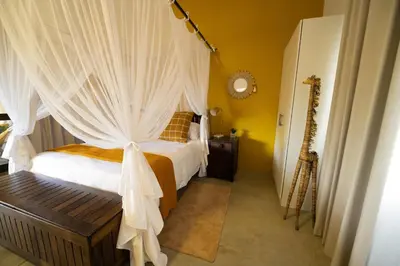 a bedroom with a bed with a canopy at Oriole Bush Cottage in Hoedspruit