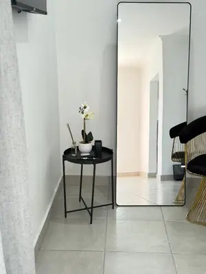 a mirror in a room with a table with flowers on it at Thandekile Garden Venue in Midrand