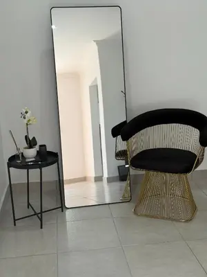 a black chair sitting in front of a mirror at Thandekile Garden Venue in Midrand