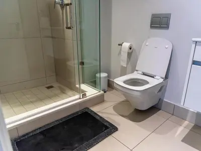 a bathroom with a toilet and a glass shower at Luxurious Apartment, Ellipse, Waterfall, Midrand in Midrand